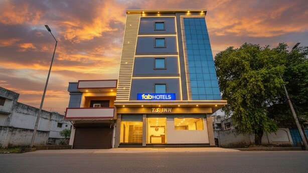 Ett modernt hotell med en skylt med texten T.S. Inn, en skylt med texten ”fabHOTELS” och fri sikt till entrén.