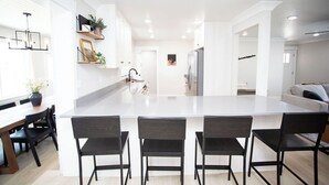 A modern kitchen with a large island, black chairs, and a dining table. - Dayton Diamond- Sleeps 10, Peaceful setting, Game room, Chef's kitchen! (Dayton)