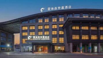 A modern hotel building with a prominent sign for 'CIGLE BY LANDISON.'