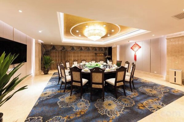 A dining room with a round table, chairs, and a chandelier.