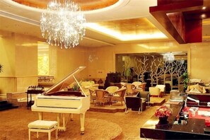 Un piano à queue, un lustre et un intérieur moderne agrémenté de sièges et d’éléments de décoration.