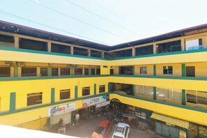 A multi-level commercial building with multiple floors, large windows, and a central open space. - RedDoorz Near SM City Muntinlupa (Muntinlupa)