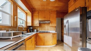 Una cucina moderna con mobili in legno, elettrodomestici in acciaio inossidabile e un'ampia finestra che offre luce naturale.