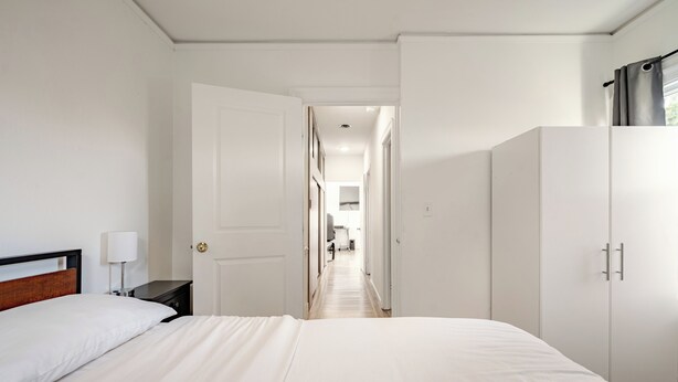 Una camera d'albergo con un letto, un comodino e un armadio.