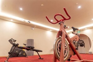 A gym with stationary bikes, a treadmill, and exercise equipment.
