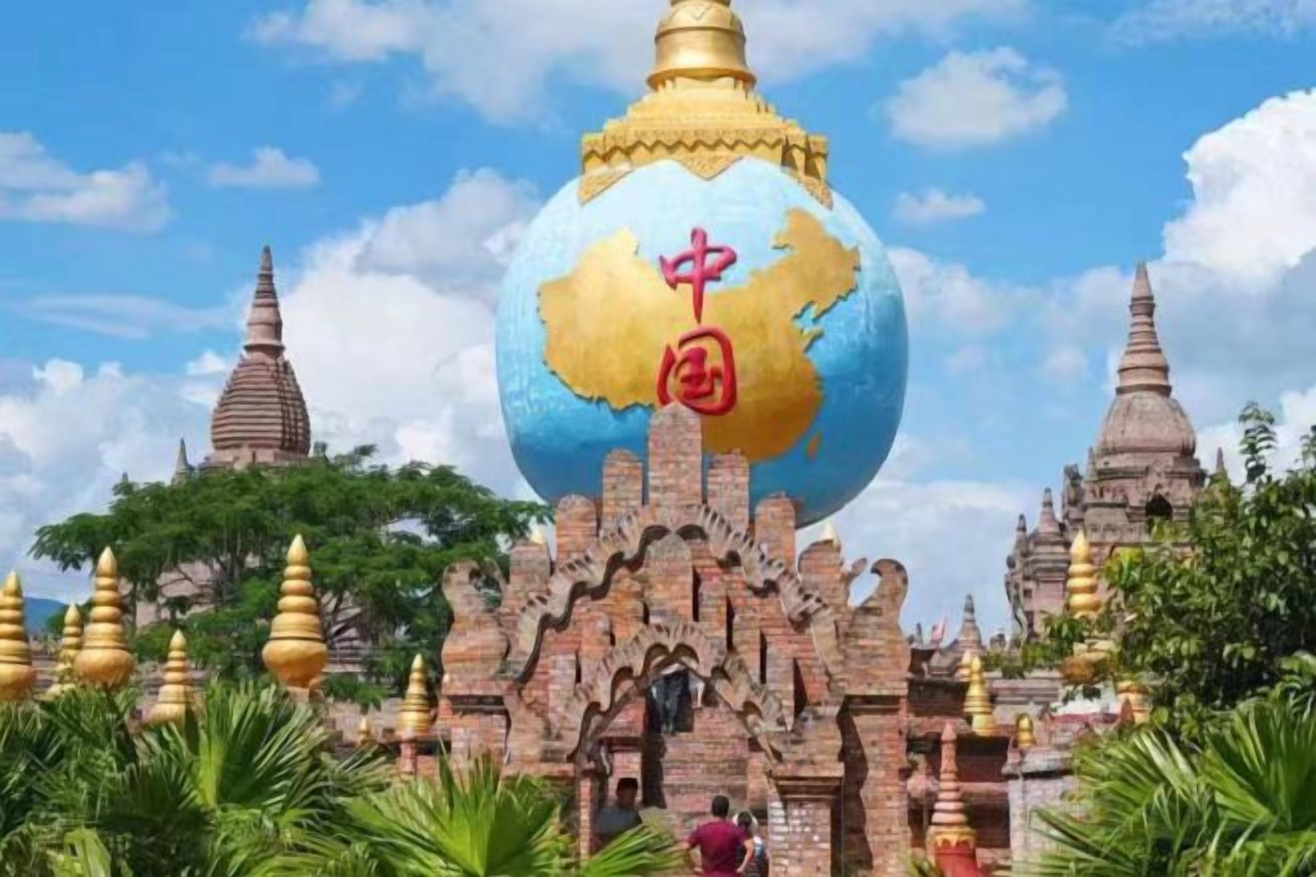 A large golden globe with Chinese characters, surrounded by traditional architecture and a clear sky.