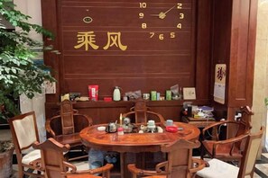 Una mesa de madera tradicional con sillas, una pared con un calendario y varios objetos en estantes.