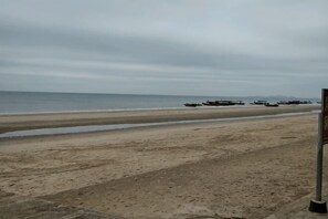 A beach with boats, a sandy shore, and a cloudy sky. - Dongxing Chengfeng Hotel (Dongxing)