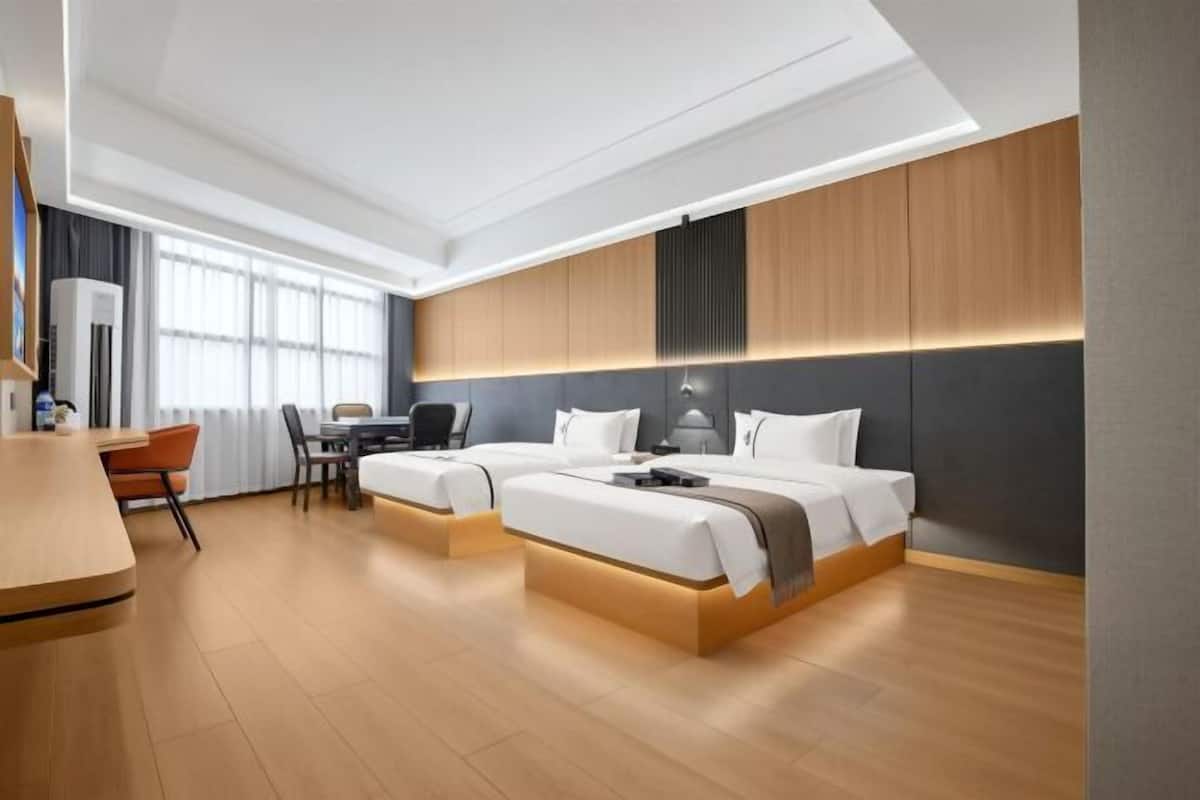 Una habitación de hotel moderna con dos camas, un escritorio y una silla.