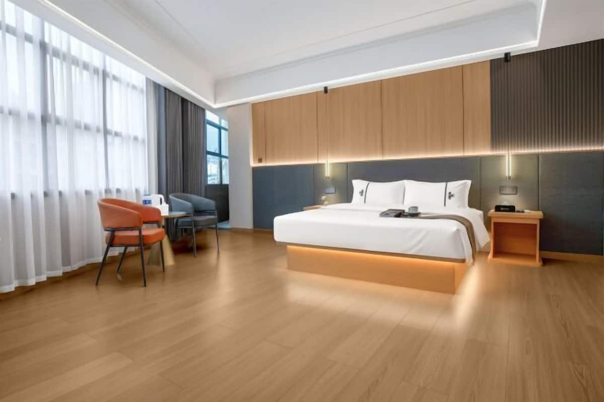 Una habitación de hotel moderna con una cama grande, un escritorio y una silla.