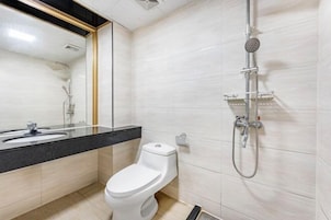 A modern bathroom with a toilet, sink, and shower.