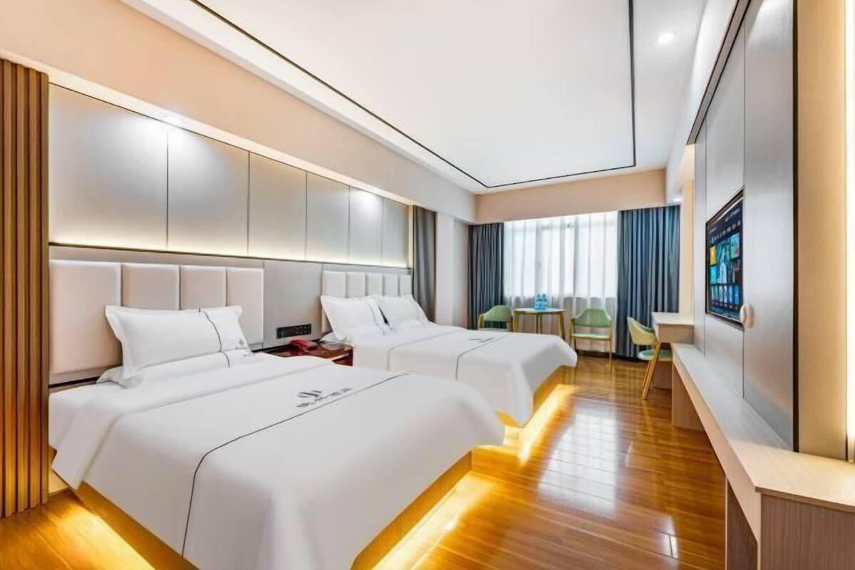 Una habitación de hotel moderna con dos camas, un escritorio y una zona de estar.
