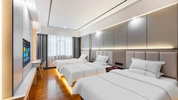Habitación de hotel con dos camas, un espejo grande y un televisor en la pared.