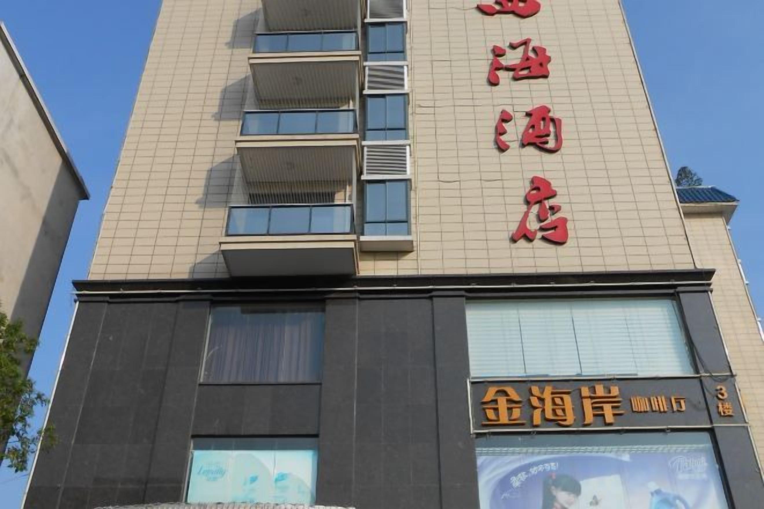 A hotel with a sign indicating it is a hotel and a restaurant named '金海岸'.