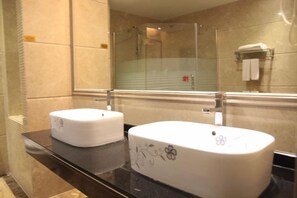 Un baño con dos lavamanos, un espejo y una zona de ducha.