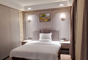 A hotel room with a bed, nightstands, a painting, and wall sconces. - Sihai Hotel (Yunfu)