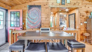 A wooden interior with a dining area, a sign reading "COCKTAILS," and a colorful abstract painting. - Picturesque Phoenix Vacation Home on Oswego River! (Phoenix)