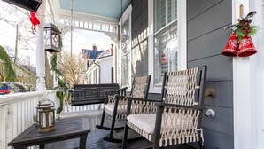 A porch with rocking chairs, a table, and a lantern.