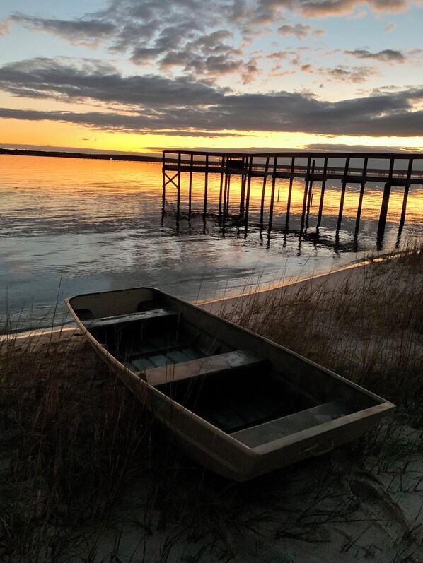 A boat on a sandy shore with a pier extending into a body of water. - Ochlocknee Bay Waterfront King Suite Private Dock Top Floor (Panacea)