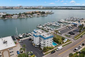A marina with boats docked, a parking lot, and a building with a blue roof. - Waterfront w/Pool! FREE Activities! ~ 22 Bayside (Clearwater)