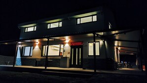 A modern two-story building with a covered outdoor area, large windows, and a visible entrance. - 58mutian B&B (Zhuangwei)