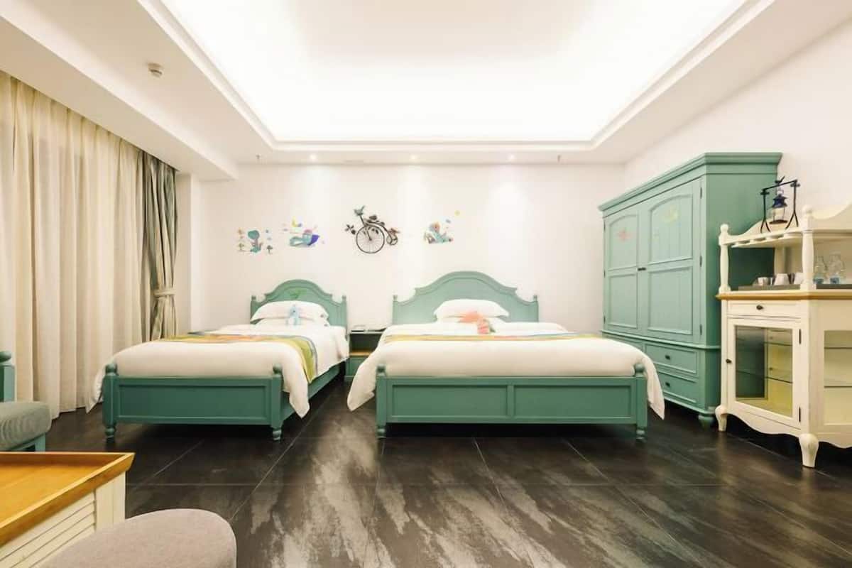 Une chambre d’hôtel avec deux lits, un bureau, une chaise, une armoire et un luminaire au plafond.