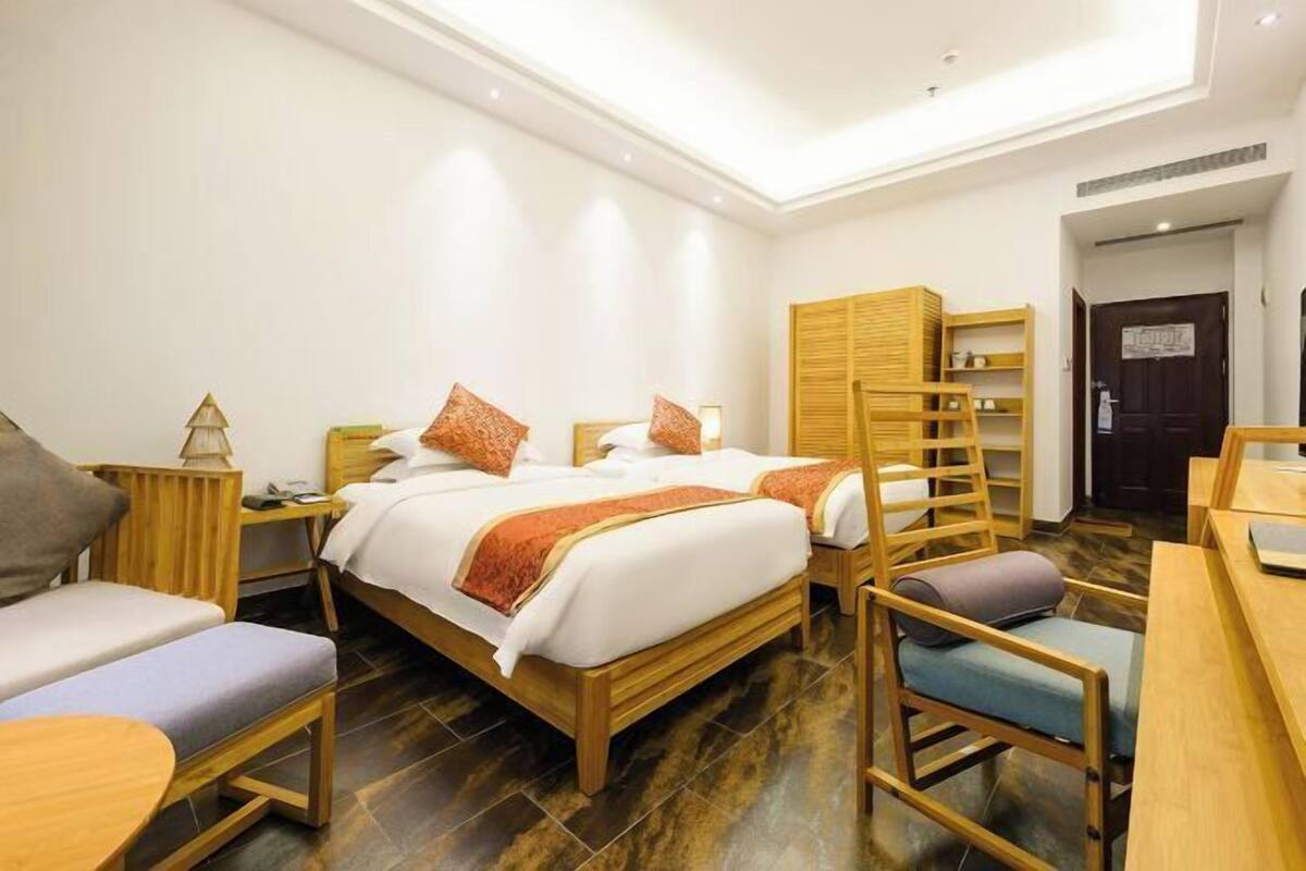 Une chambre d’hôtel comprenant un lit, deux chaises, un bureau, une armoire et une porte.