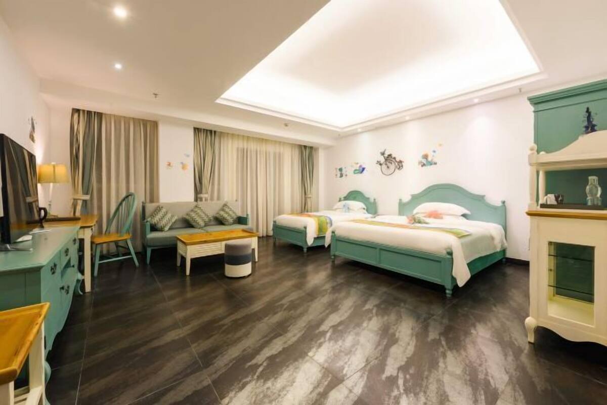 Une chambre d’hôtel avec un lit, un canapé, un bureau et une chaise.