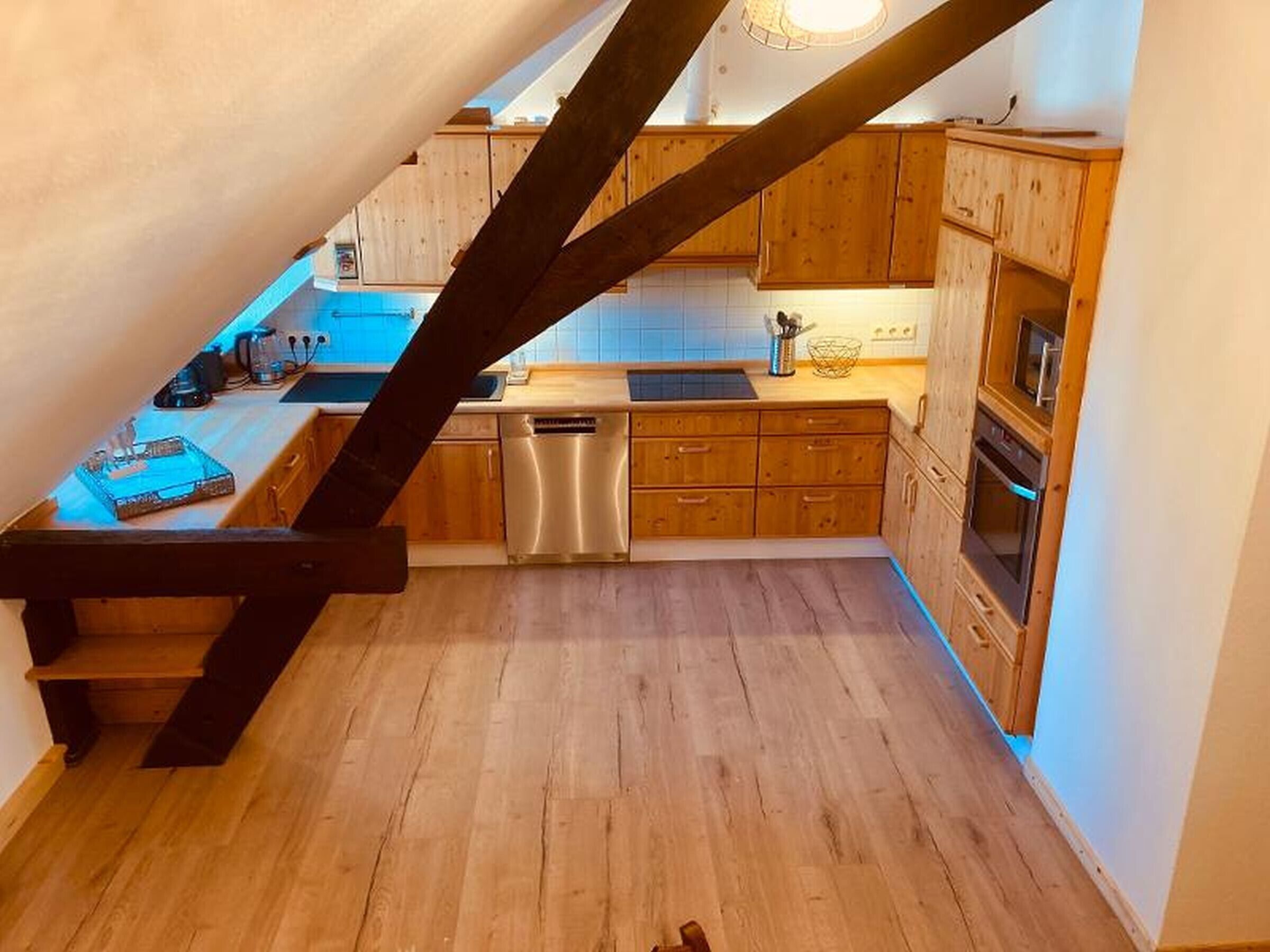 Una cocina con armarios de madera, lavavajillas y estufa.