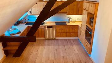 Una cocina con armarios de madera, lavavajillas y estufa.