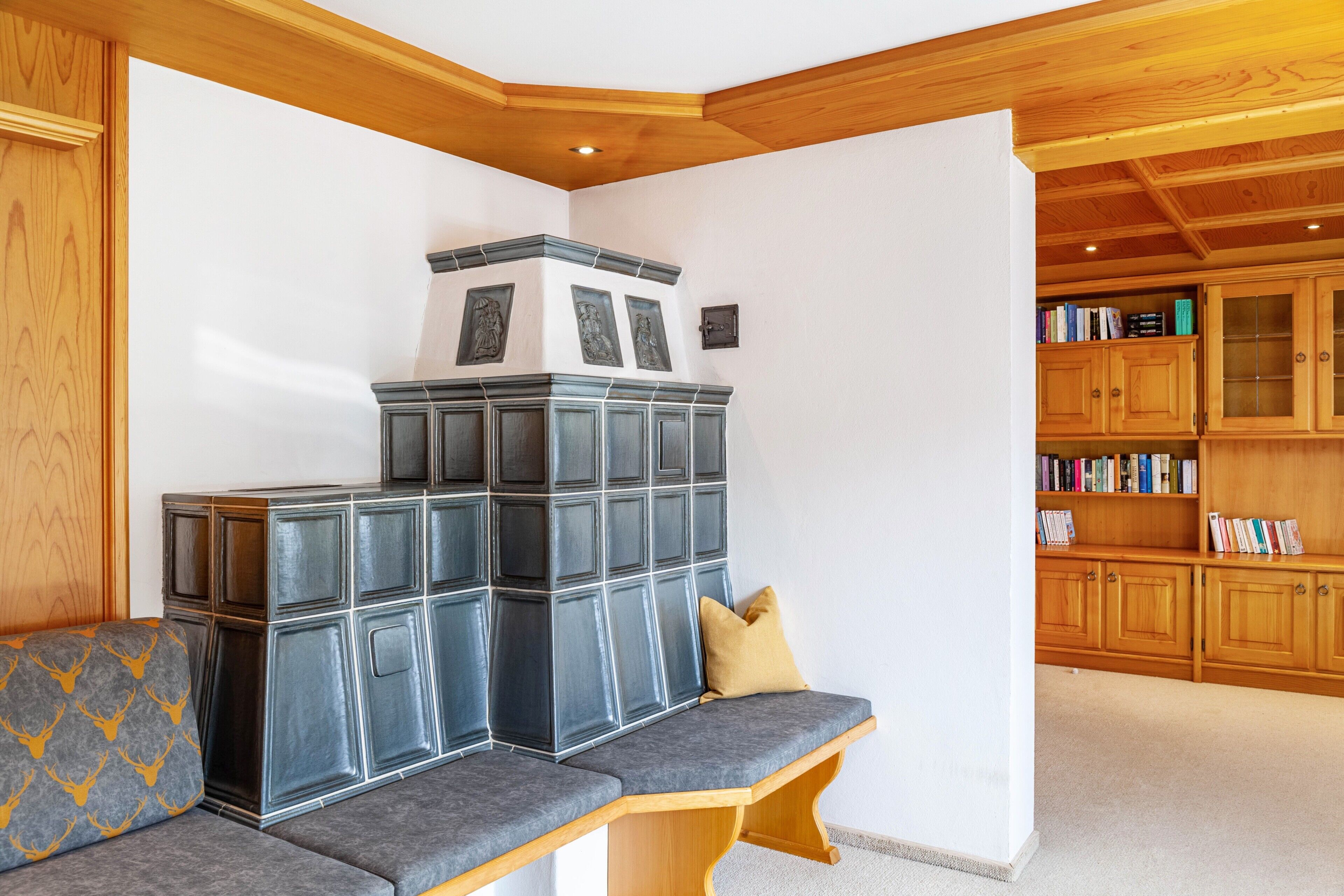 Un coin salon avec un banc, un meuble mural décoratif et une bibliothèque.