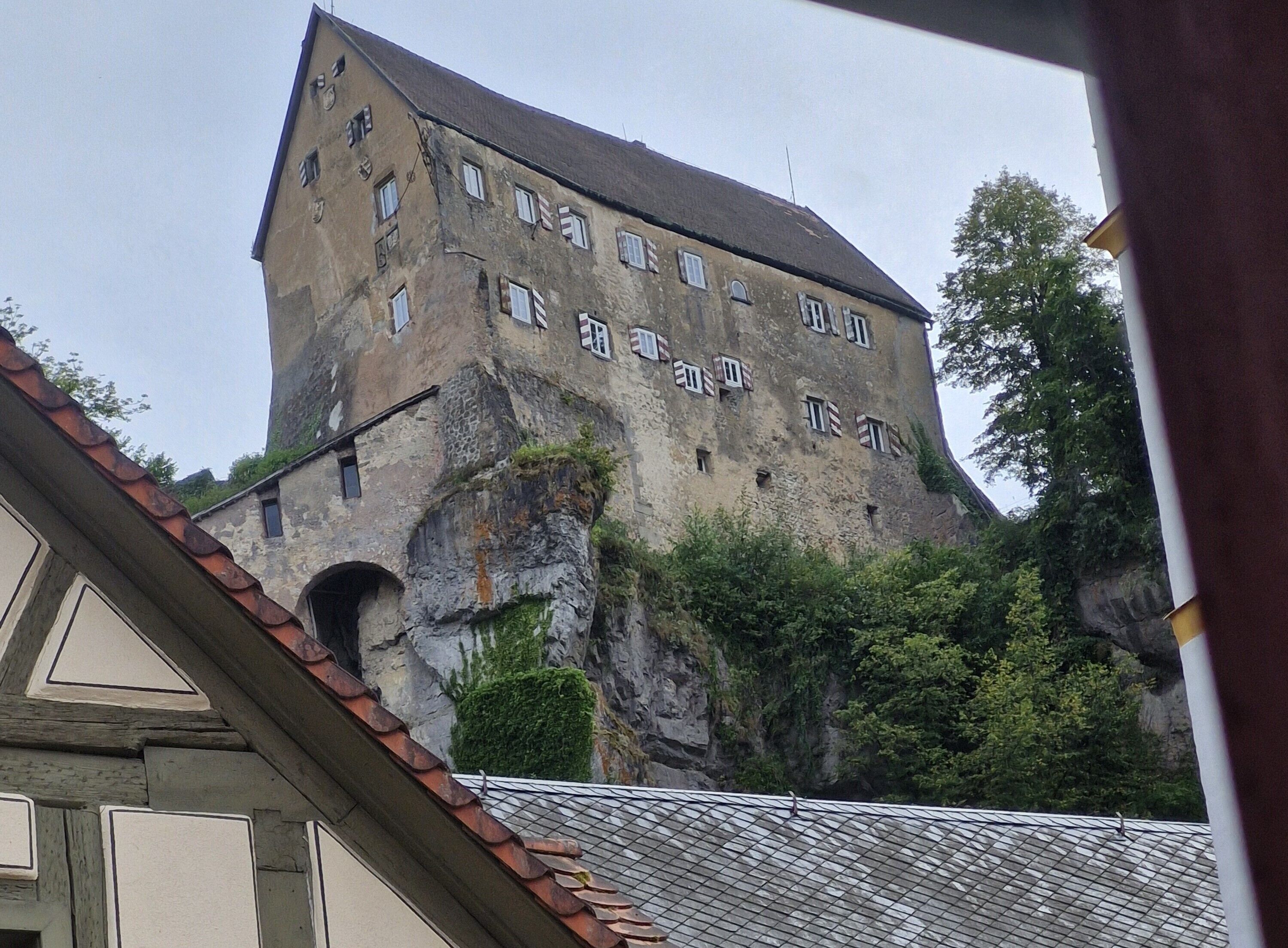 Ein historisches Gebäude mit einer steilen, steinernen Fassade und zahlreichen Fenstern.