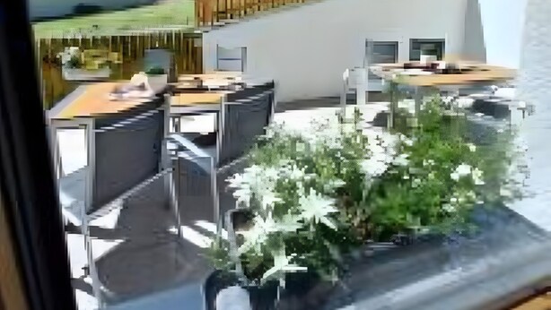 Un hôtel moderne doté d’une terrasse, d’un espace extérieur aménagé et offrant une vue sur la montagne.