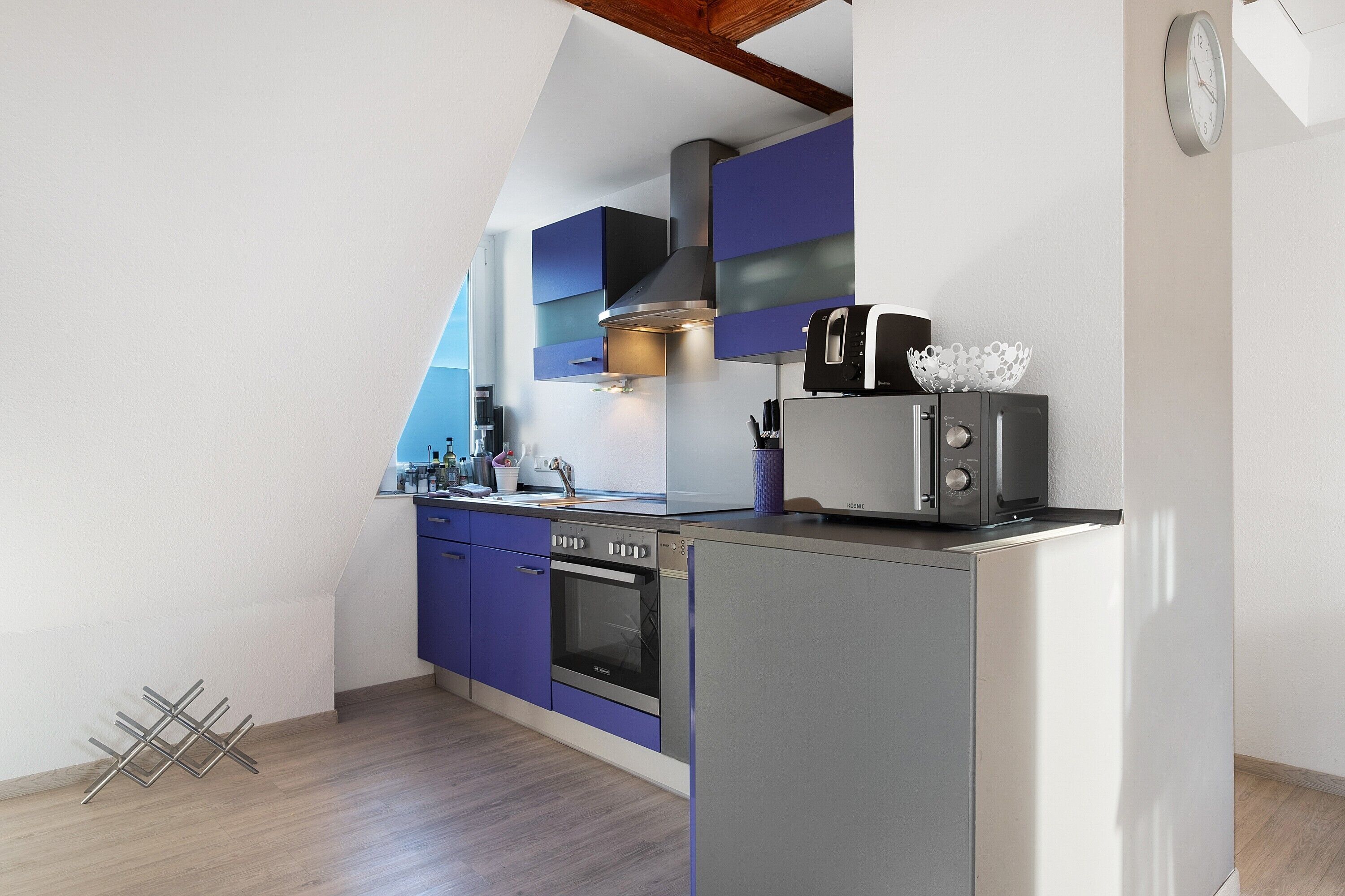 Een moderne keuken met een inbouwoven, een magnetron en een broodrooster.