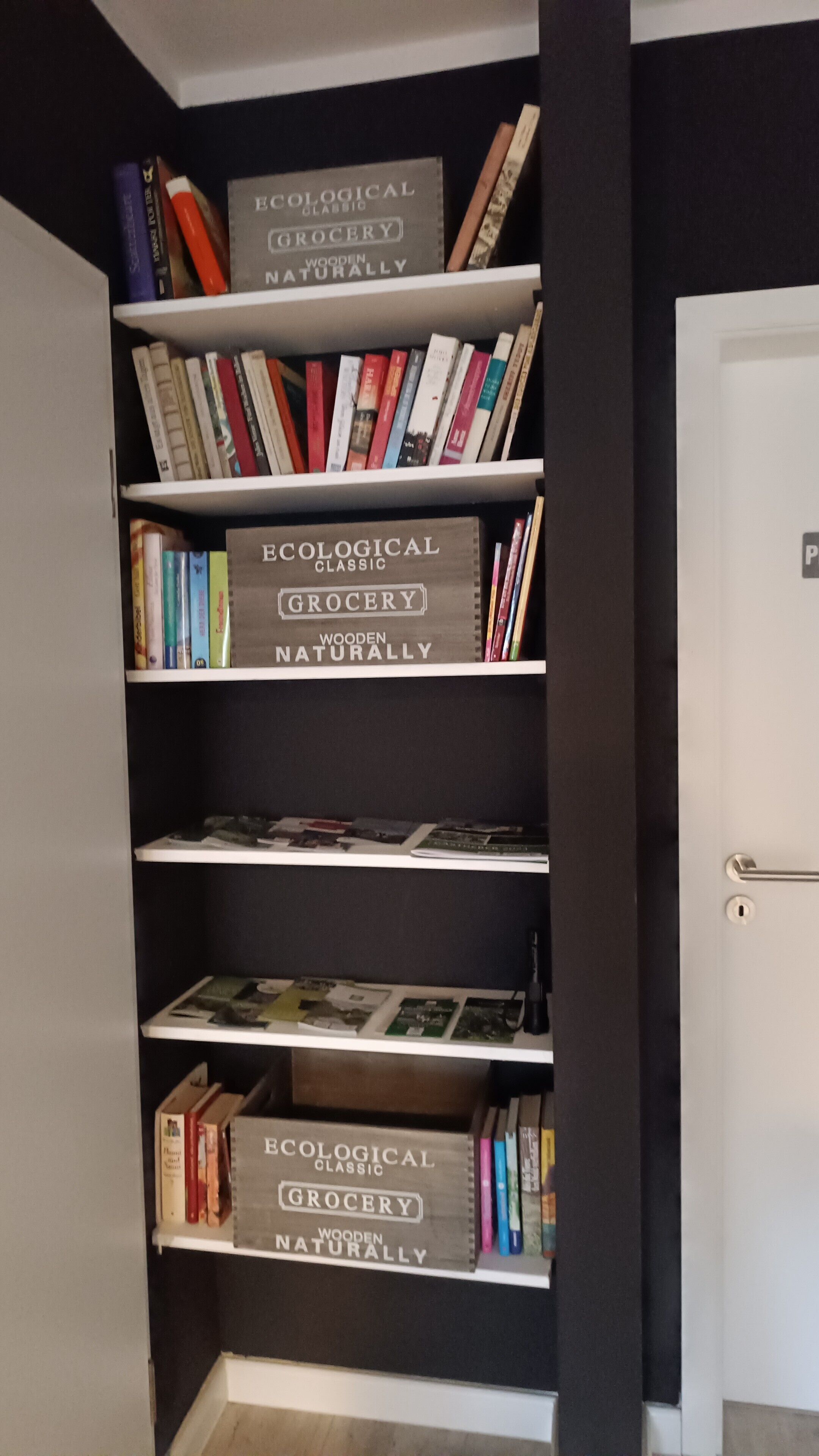 A bookshelf with multiple shelves, each labeled 'Ecological Grocery Naturally.'