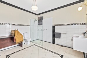 A modern bathroom with a glass-enclosed shower, a white sink, and a wooden vanity.
