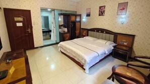 Une chambre d’hôtel avec un lit, une armoire, un bureau et une chaise.
