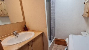 Ein Badezimmer mit Waschbecken, Toilette und Duschvorhang.