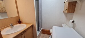 A bathroom with a sink, toilet, and shower curtain.