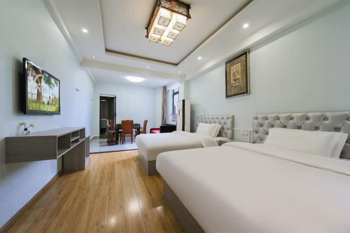 Une chambre d’hôtel avec deux lits, une télévision, un bureau et un coin repas.