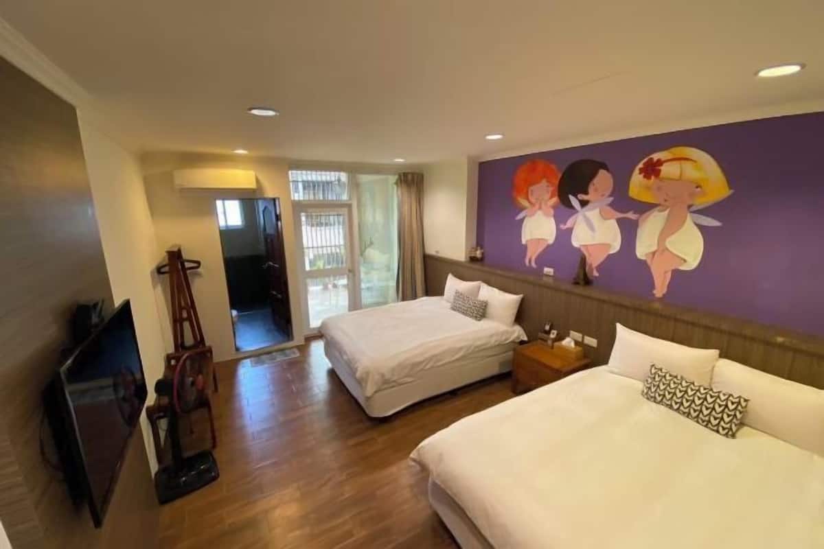A hotel room with two beds, a TV, a painting, and a window.