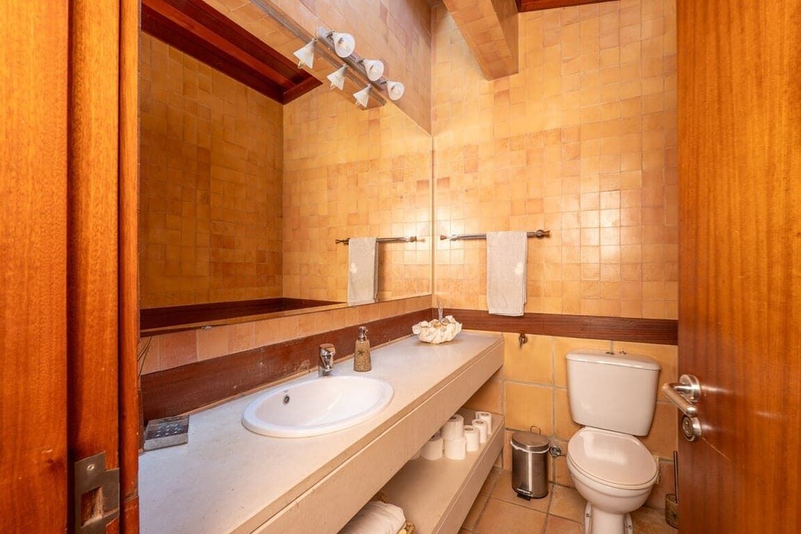 Un baño con dos lavamanos, un inodoro y un espejo.