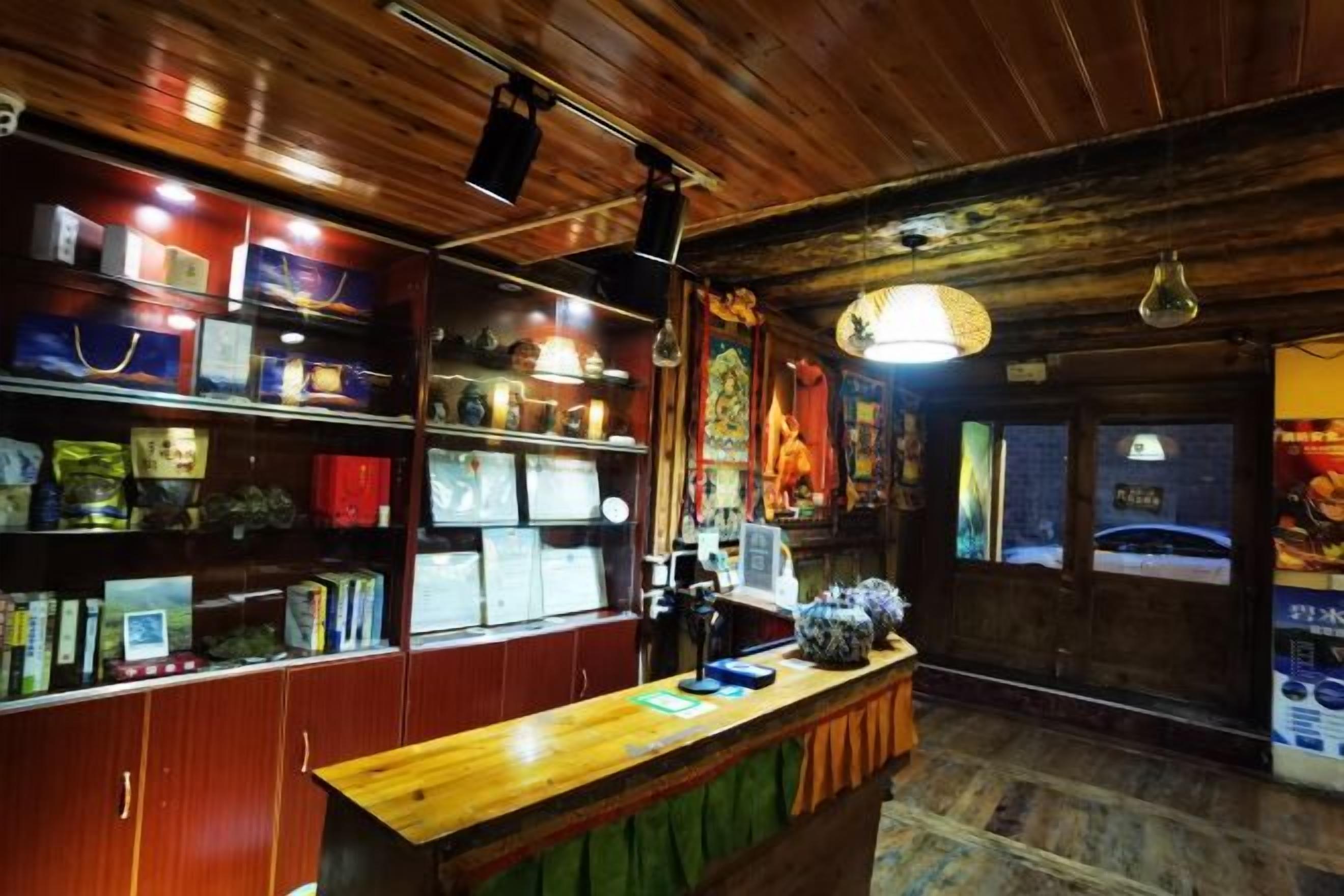 A wooden interior with shelves displaying various items, a counter with a lamp, and a poster on the wall.