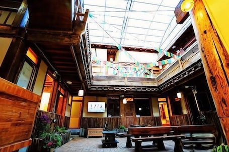 A traditional inn with wooden architecture, a central courtyard, and a balcony.. Gesajibu Inn