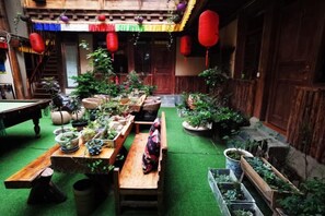 A courtyard with a wooden table, potted plants, and a bench. - Gesajibu Inn (Shangri-La)