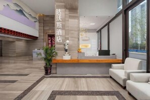 A hotel reception area with a reception desk, seating area, and a large window. - Hotel & Davos (Chongqing Ranjiaba Light Rail Station) (Chongqing)