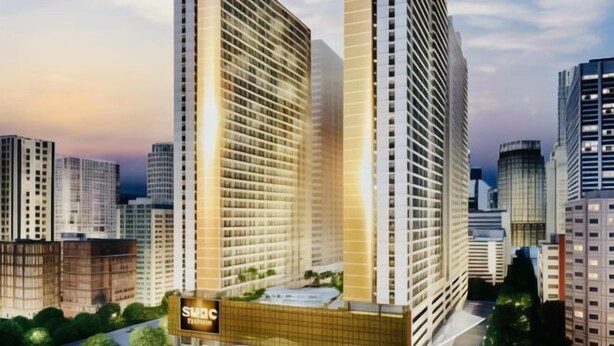 Un moderno edificio de gran altura con un letrero llamativo que dice 'SMDC'.