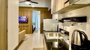Una cocina moderna con un lavamanos de acero inoxidable, un hervidor y un ventilador de techo.