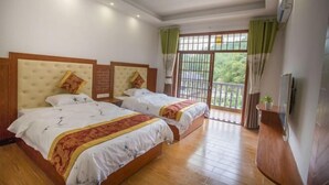 A hotel room with two beds, a balcony with a view, and an air conditioning unit on the wall. - Haolaiju Inn (Zhangjiajie)