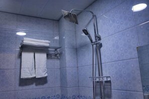 A bathroom with a shower, a towel rack, and a patterned wall. - Haolaiju Inn (Zhangjiajie)